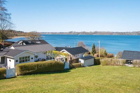 An elevated holiday cottage with a panoramic view of Vejle Fjord. From the house there is a pathway that leads down to the sea with a bathing jetty. There is a shared playground by the house. The interior of the house is bright with a slanting ceilin...