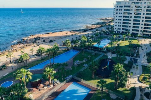 Este apartamento frente al mar en Punta Prima, Torrevieja, ofrece alojamiento de lujo con tres dormitorios y dos baסos, ideal para familias o grupos de amigos. Cuenta con un jacuzzi privado, una piscina infinita y dos terrazas con impresionantes vist...