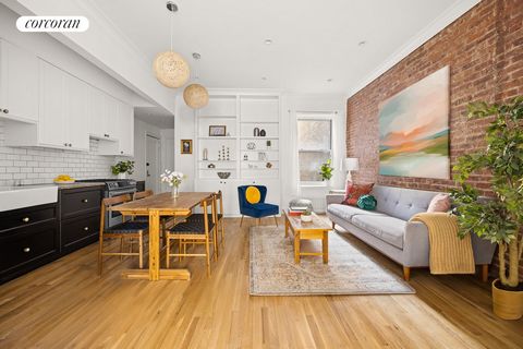 This beautifully renovated pre-war co-op features a living room distinguished by an exposed brick wall that adds warmth and texture to the open space, complemented by high ceilings and custom built-in bookcases, creating a dramatic living and dining ...