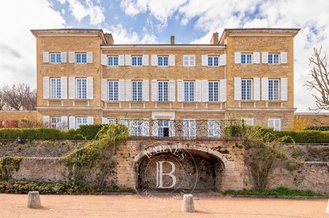 LISSIEU. In a superb golden stone castle from the end of the 18th century, located in a one-hectare wooded park, this exceptional apartment on the ground floor offers you a surface area of approximately 130 sqm with a private terrace of 64 m² approxi...