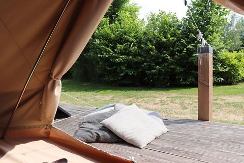 These beautiful large Glamor bell tents stand next to each other on a wooden platform and are tastefully decorated. A small fire pit has been made next to the tents, with a tripod with a pan above it. If you unzip the back entrance of the tent, the s...