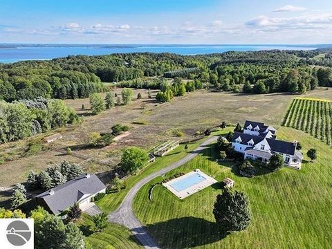 GREAT NEWS! New owner can assume current owner's 4.35% mortgage on this spectacular, chic & artistic farmhouse in Leelanau county is surrounded by 17 acres of cherry orchards and vineyards. A Ken Richmond designed home which boasts its' own 3 acre wo...