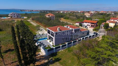 Beautiful newly built villa for sale in Privlaka, first row to the sea. The newly built villa is modernly decorated, with extremely high-quality materials and equipment. The villa has an interesting architectural design, and has connected it into an ...