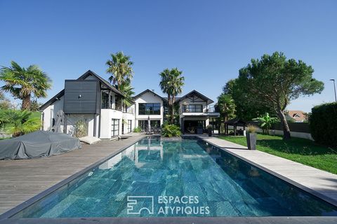 On the outskirts of Pau, this splendid architect-designed house with the appearance of a Californian Villa develops 350 m2 with natural swimming pool and exotic garden on a plot of more than 3,000 m2. Its modular design blends harmoniously into the s...