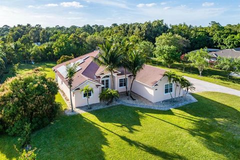 Jupiter Farms 4BR/3BA CBS construction home with extraordinary space and extra rooms to create your own ideal living space. Features include vaulted ceilings, dual gas fireplace, gourmet kitchen (can be gas) with slate finish appliances and granite c...