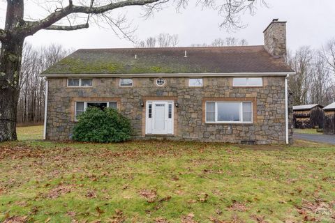 Enjoy far reaching views from this roomy stone house overlooking a lush valley in beautiful Columbia County! Set atop a hill at the end of a private drive on a quiet country road, the house looks over 77 acres of open fields, woods with maples to tap...