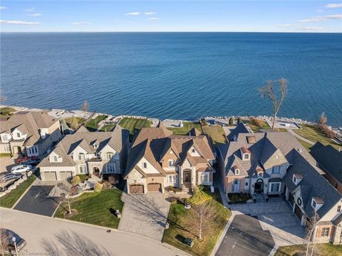 Discover a remarkable custom-built lakefront masterpiece on the pristine shores of Lake Ontario. Step inside to experience over 4,500 sq ft above grade and soaring ceilings on all three levels, accentuated by intricate tray and coffered designs. An e...