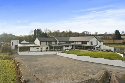 Entering through the grand hallway, you are immediately captivated by the impressive curved staircase with a galleried landing, where large windows frame breathtaking views of the surrounding landscape. The heart of the home is the main Porcelanosa-d...