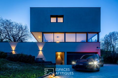 In the town of Saint-Romain-au-Mont d'Or and close to the city centre, this magnificent architect's house is set on a plot of 1027m2 and enjoys a 180° view from the Monts d'Or massifs to the Val de Saône. The living space, with its many openings to t...